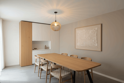 Lustre en bois suspendu au-dessus d'une grande table en bois dans une salle à manger moderne.