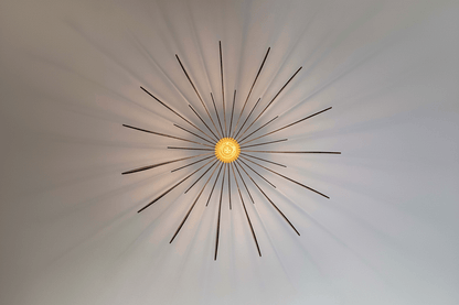 Lustre Fleur en bois avec une ampoule centrale, projetant des ombres douces sur le plafond.